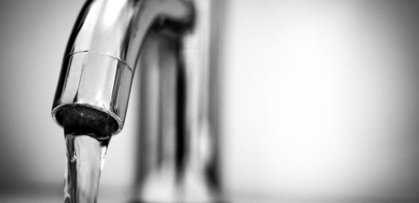 macro photography of a stainless steel faucet